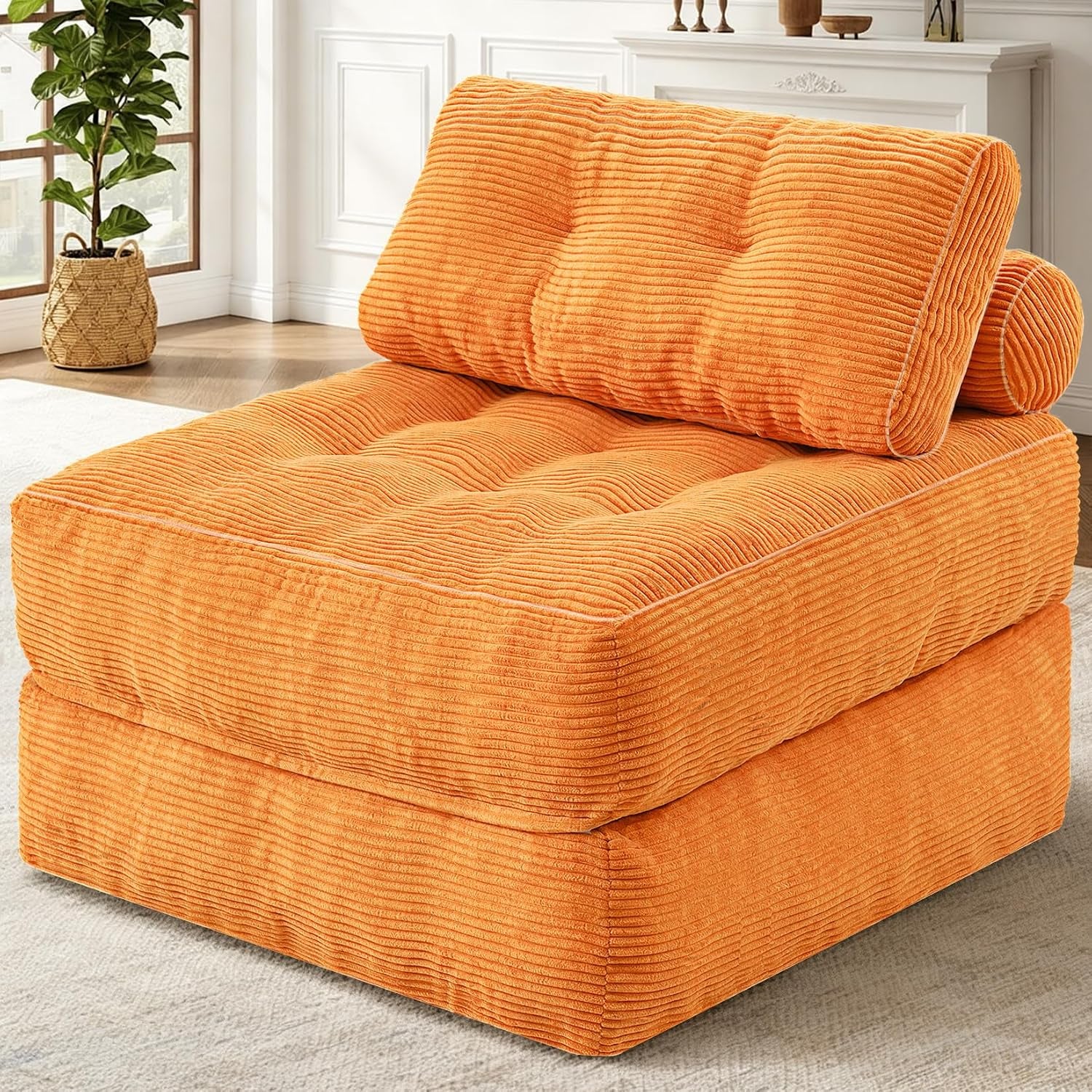 Three-quarter view of a single corduroy foldable sofa chair in vibrant orange in a styled living room.
