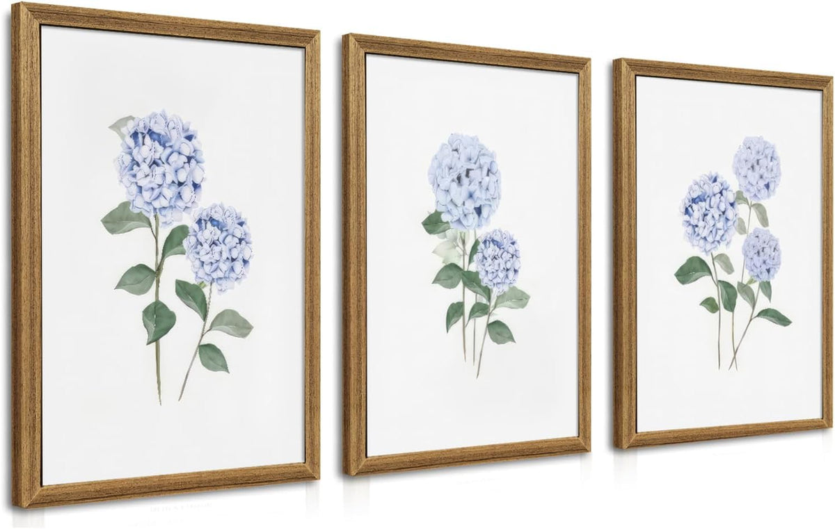 Three framed prints with pale blue hydrangea illustrations on white backgrounds, arranged side by side at an angle.