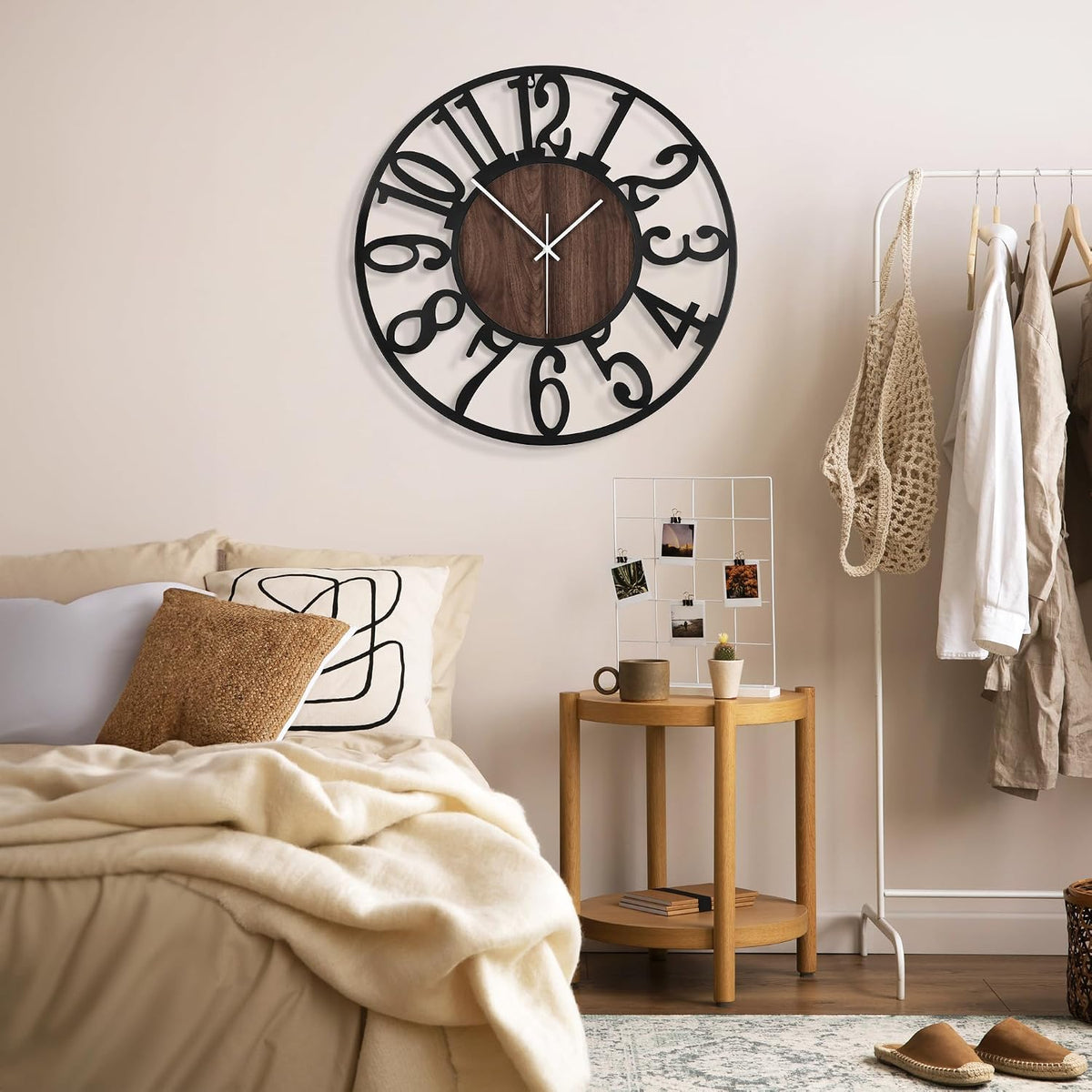 Bedroom corner with neutral bedding and the black numeric clock mounted above a small wooden side table