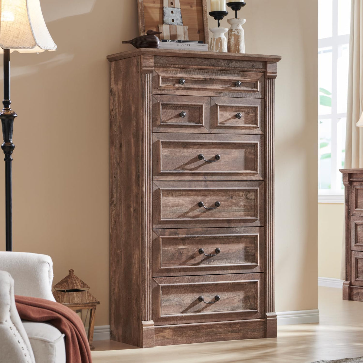 Tall five-drawer chest in warm brown wood finish with paneled drawer fronts and dark handles.