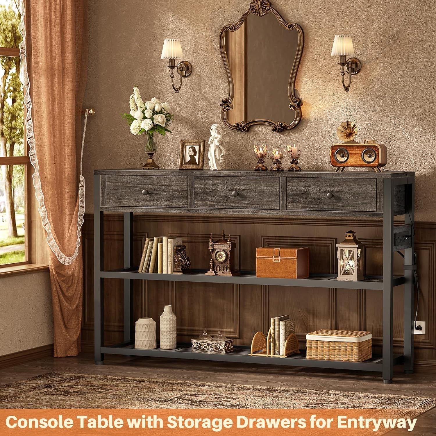 Grey console table with three drawers and two slatted shelves styled under an ornate mirror and wall sconces