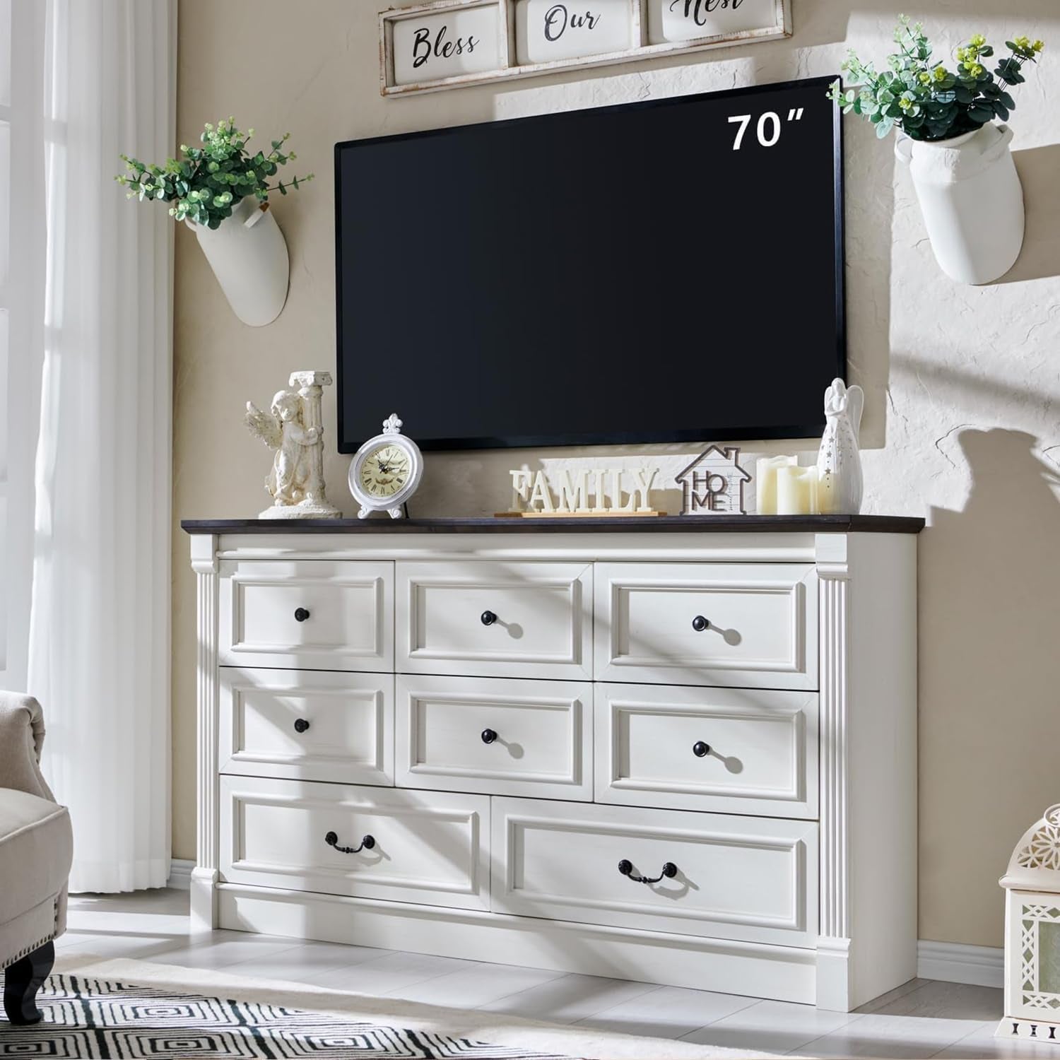 Wide white dresser with nine drawer fronts and dark top, shown under a wall-mounted TV.