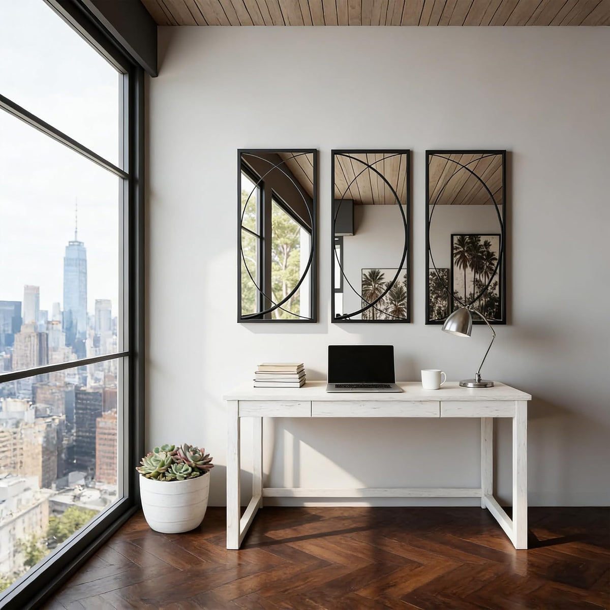 Set of three slim black rectangular mirrors with intersecting circular details mounted above a white desk beside large city‑f