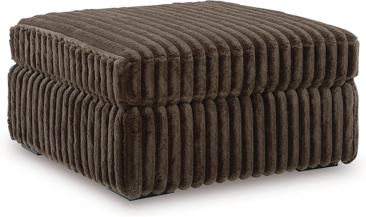 Three-quarter view of a square chocolate-brown jumbo-corduroy ottoman with vertical channel tufting.