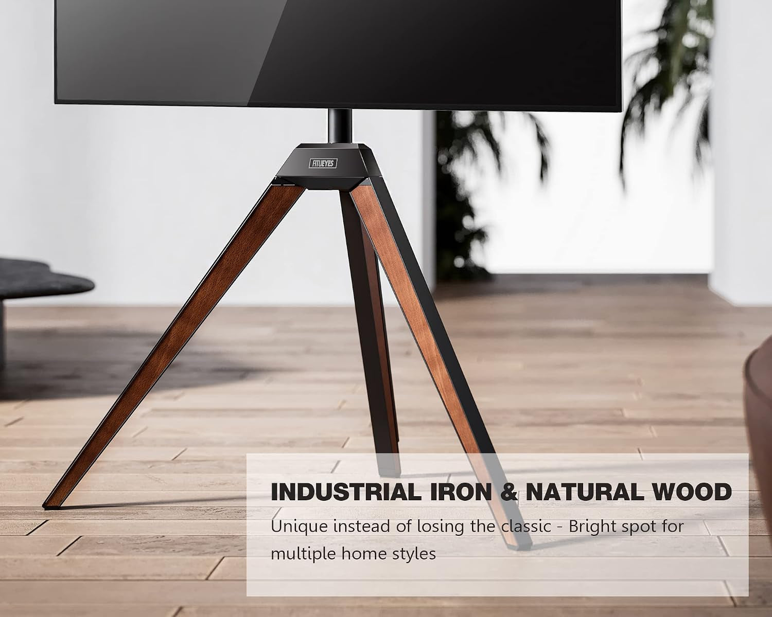 Close-up of tripod base showing beech wood legs with black metal trim on a hardwood floor.