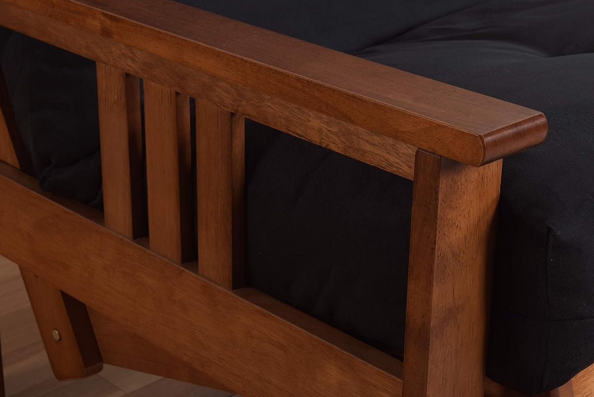 Close-up of warm-toned wooden arm and slatted frame with a dark fabric mattress tucked behind.