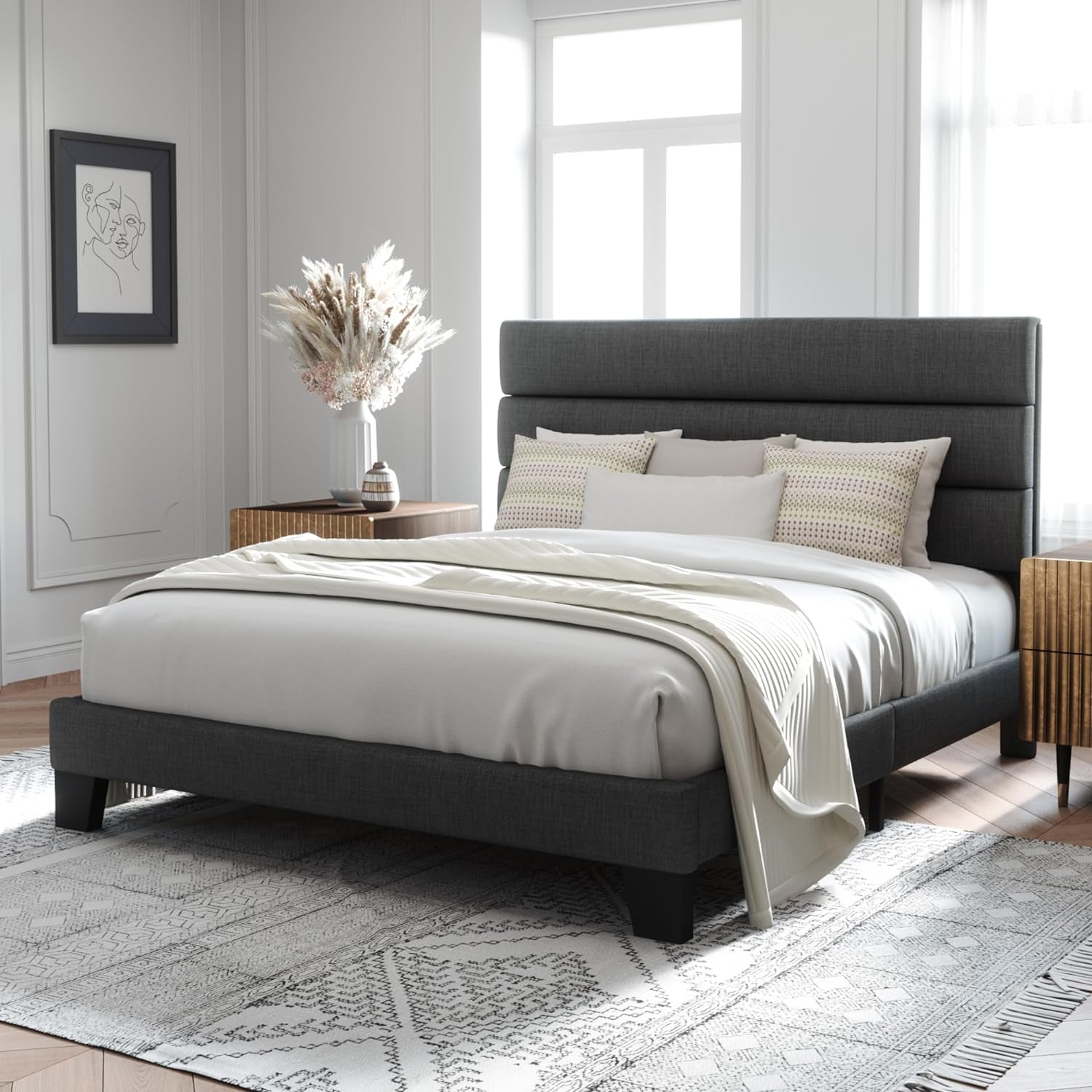 Three-quarter bedroom view of a dark gray upholstered bed with a tall segmented headboard and white bedding.