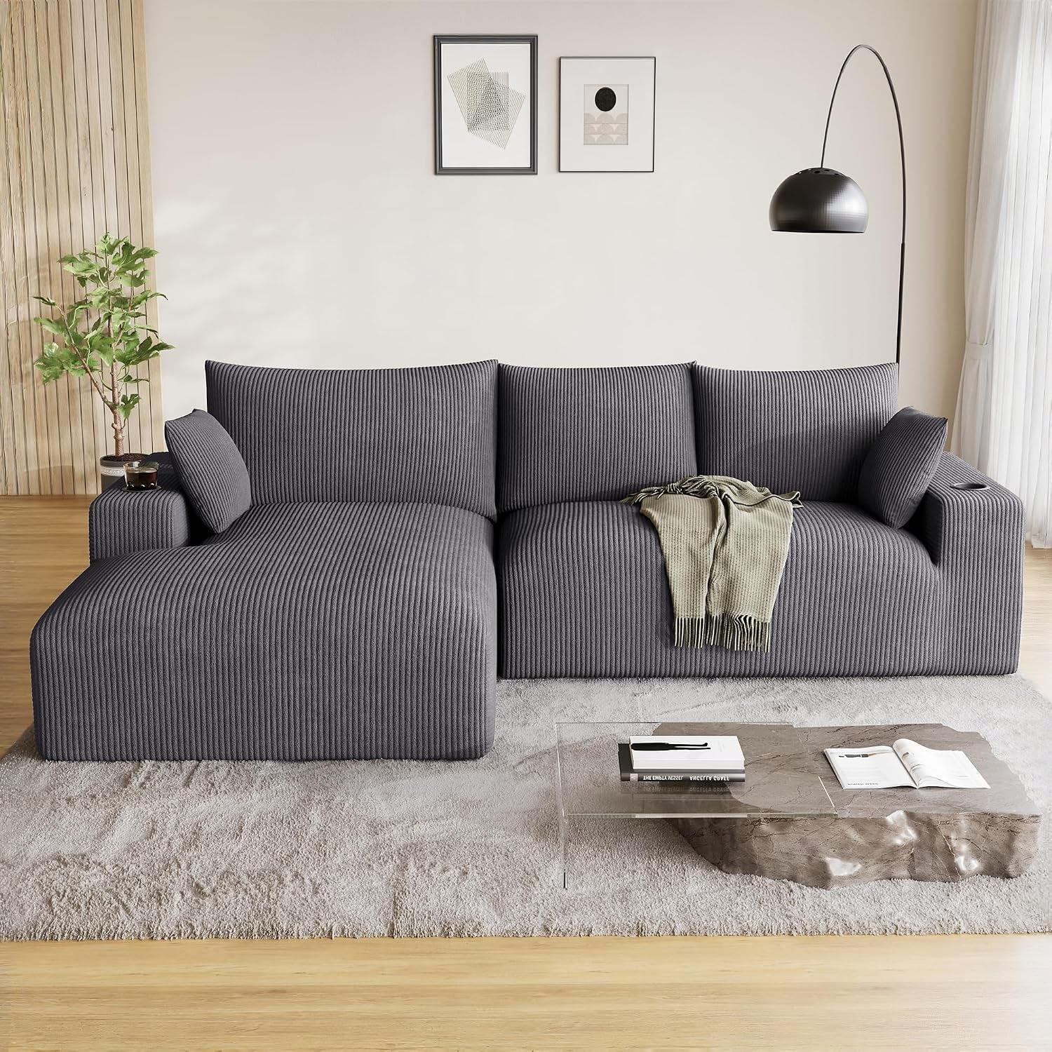Dark gray L-shaped modular sectional with left chaise centered against a neutral wall and rug.