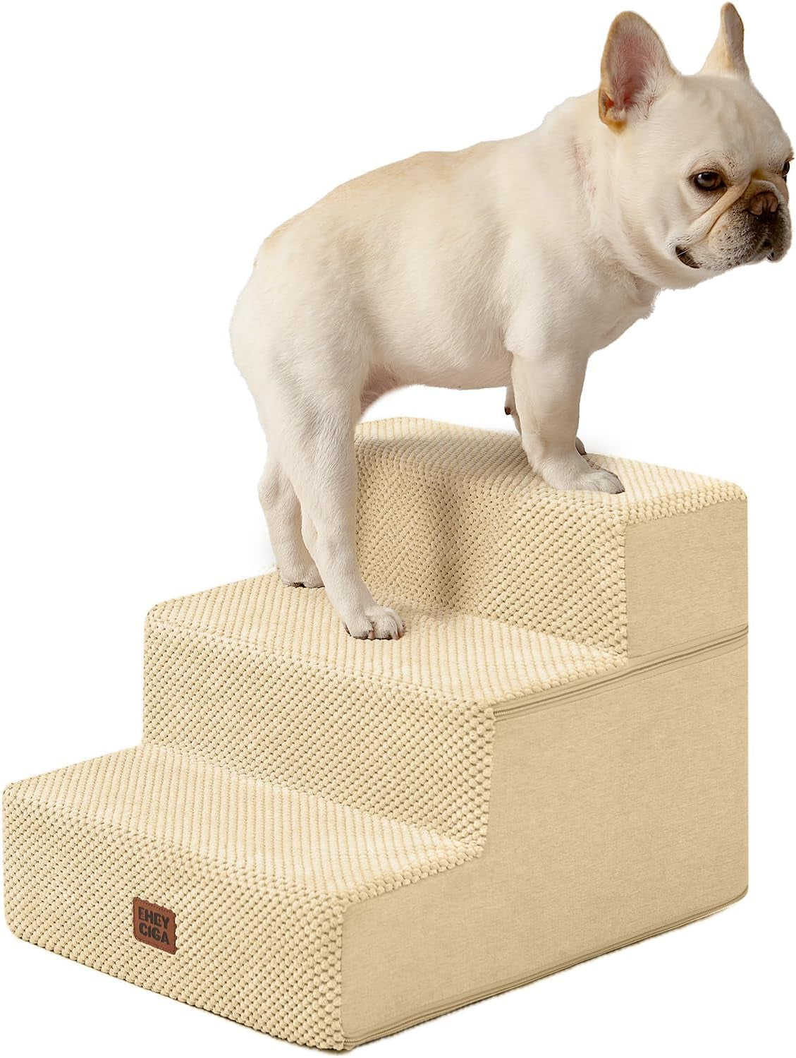 Three-step foam pet stairs in pale beige with a small cream French bulldog posed on the middle step.