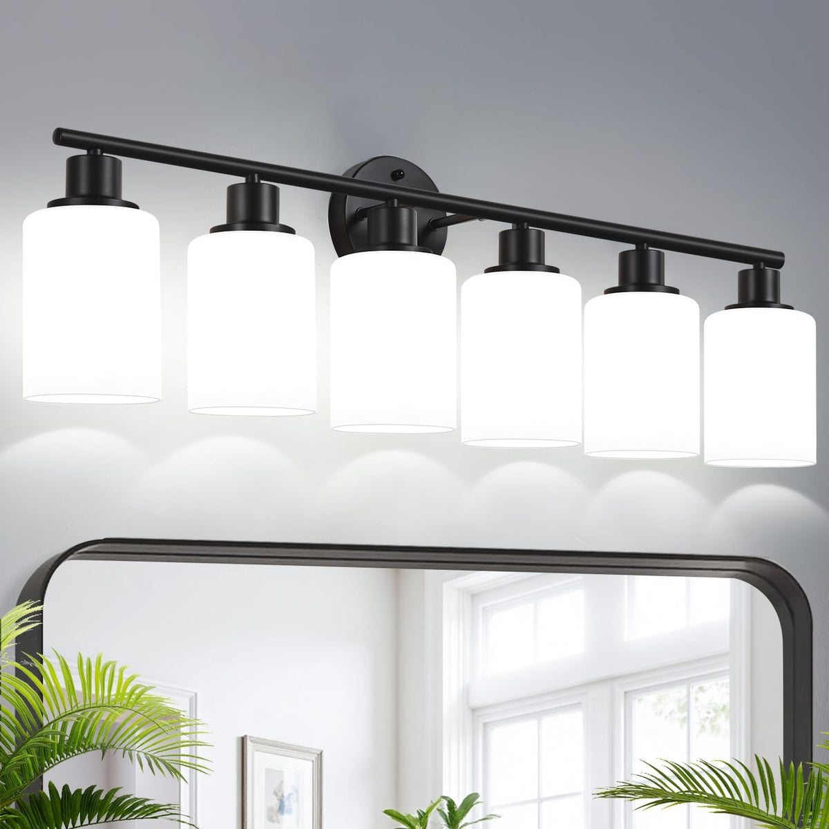 Wide shot of a long bathroom vanity light with six white cylindrical glass shades over a mirror.