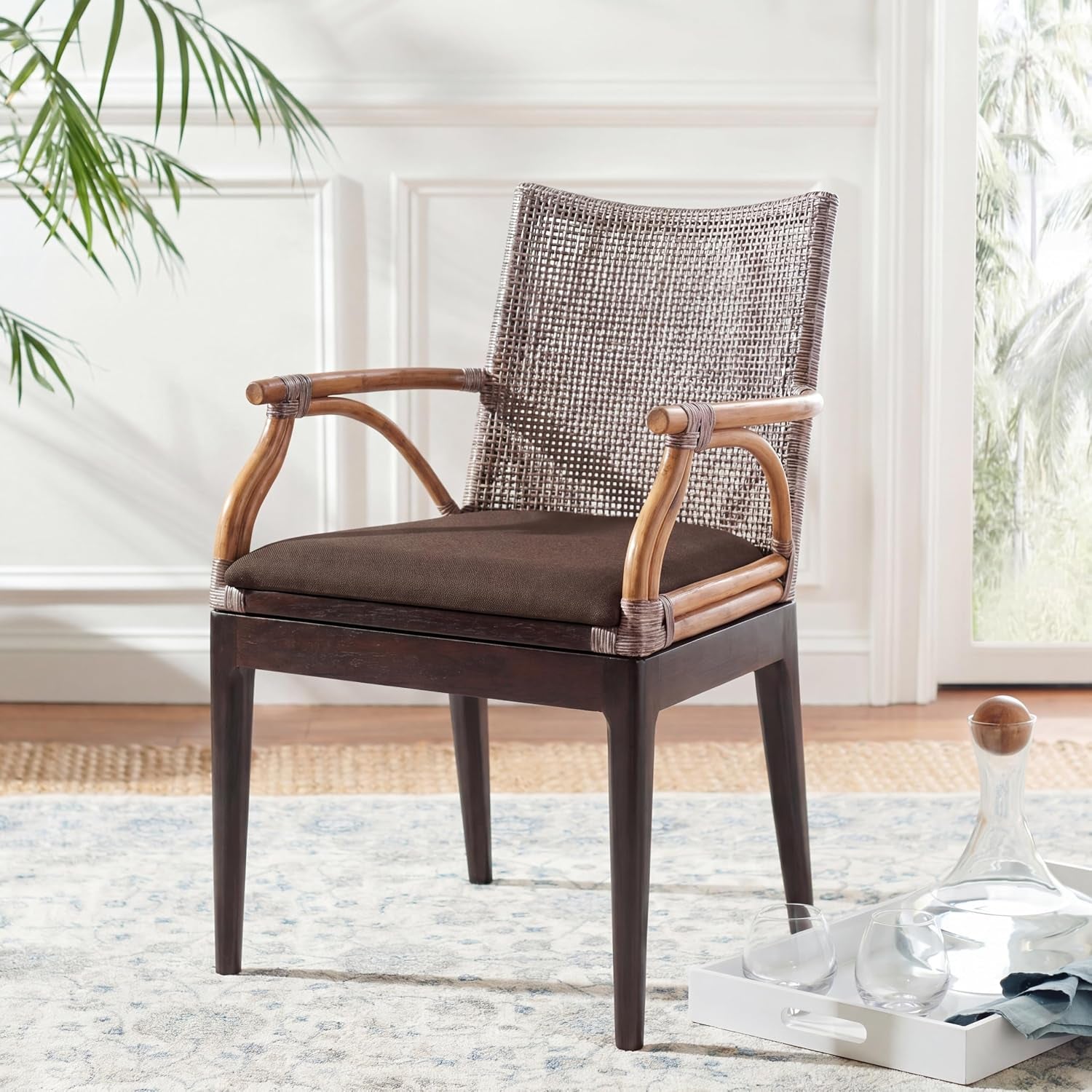 Full view of a rattan-back armchair with dark wood frame and brown upholstered seat in a bright room.