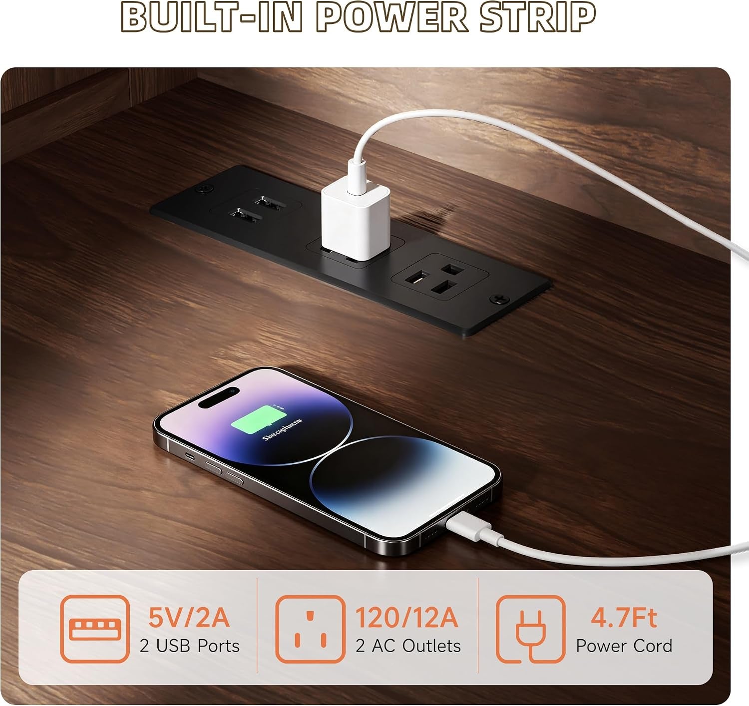 Close-up of the built-in power strip on the tabletop showing two AC outlets and two USB ports with a phone charging