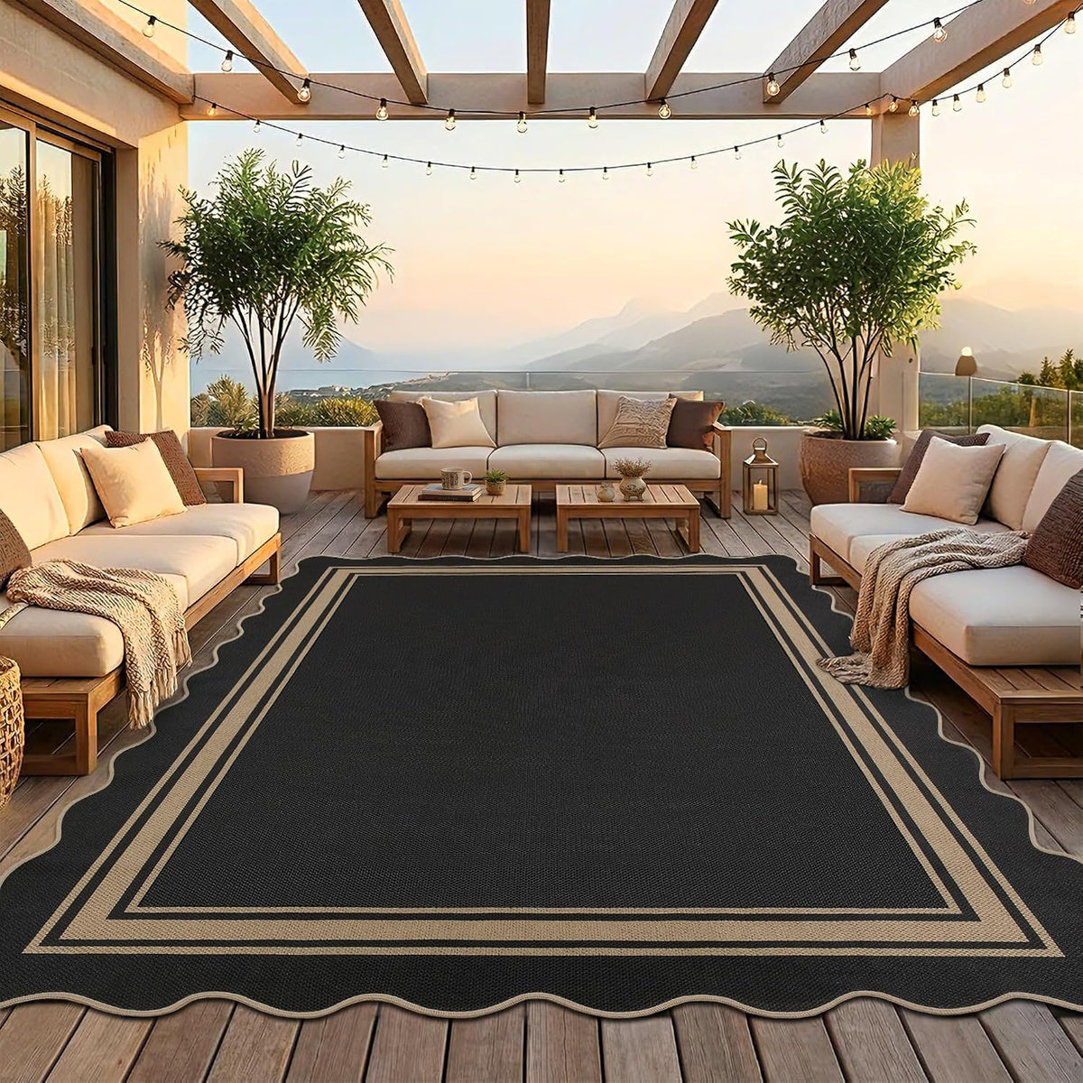 Large black scalloped rug centered under outdoor seating on a wood deck at sunset