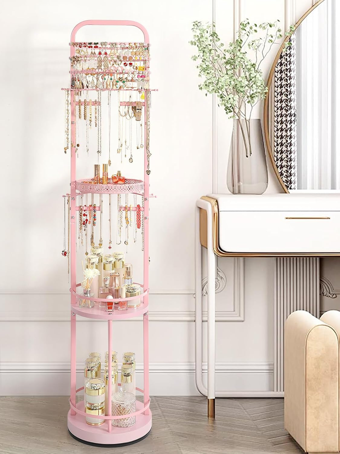 Pink three-tier jewelry organizer showing shelves filled with skincare bottles and hanging necklaces