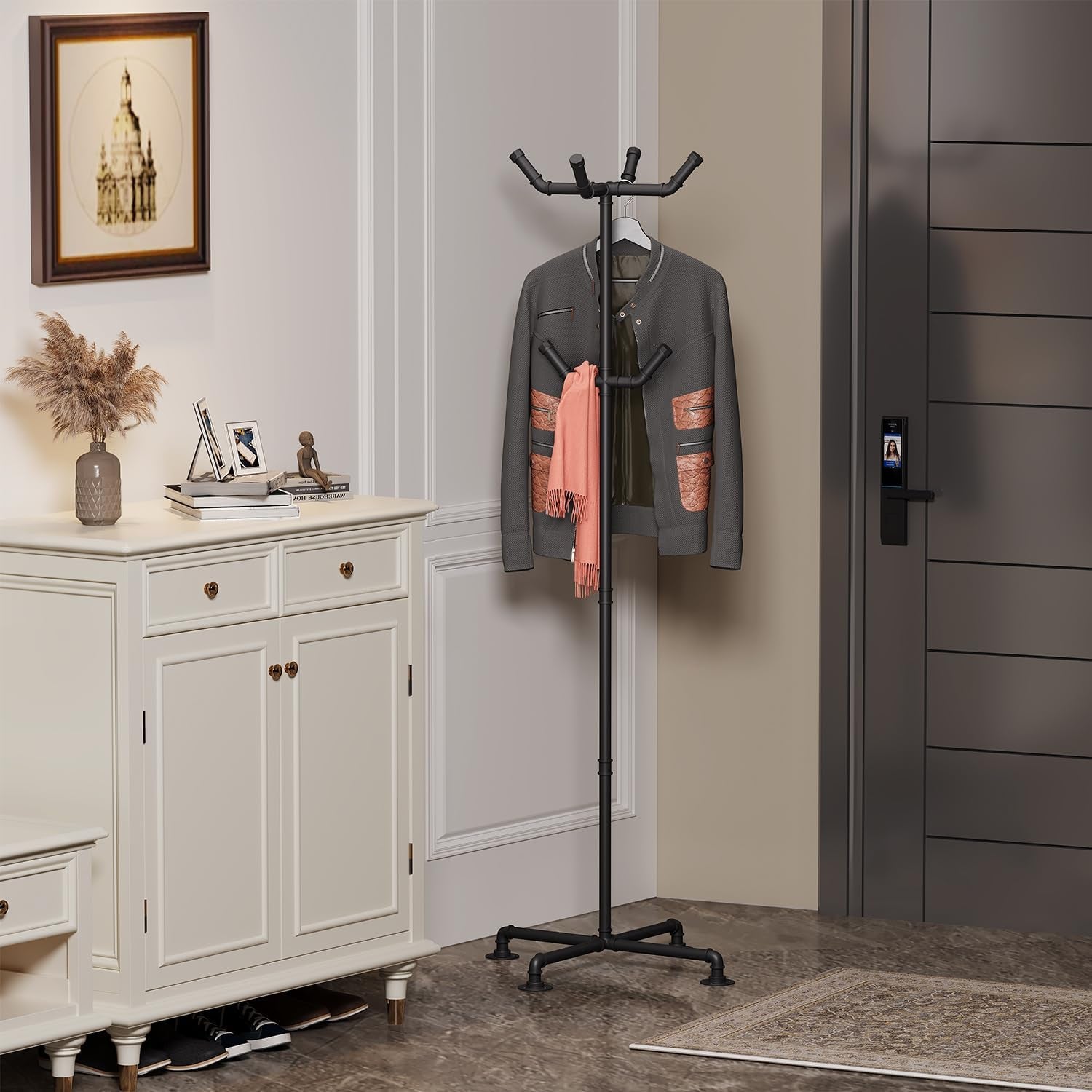 Black freestanding coat rack positioned in an entryway next to a white cabinet and an interior door
