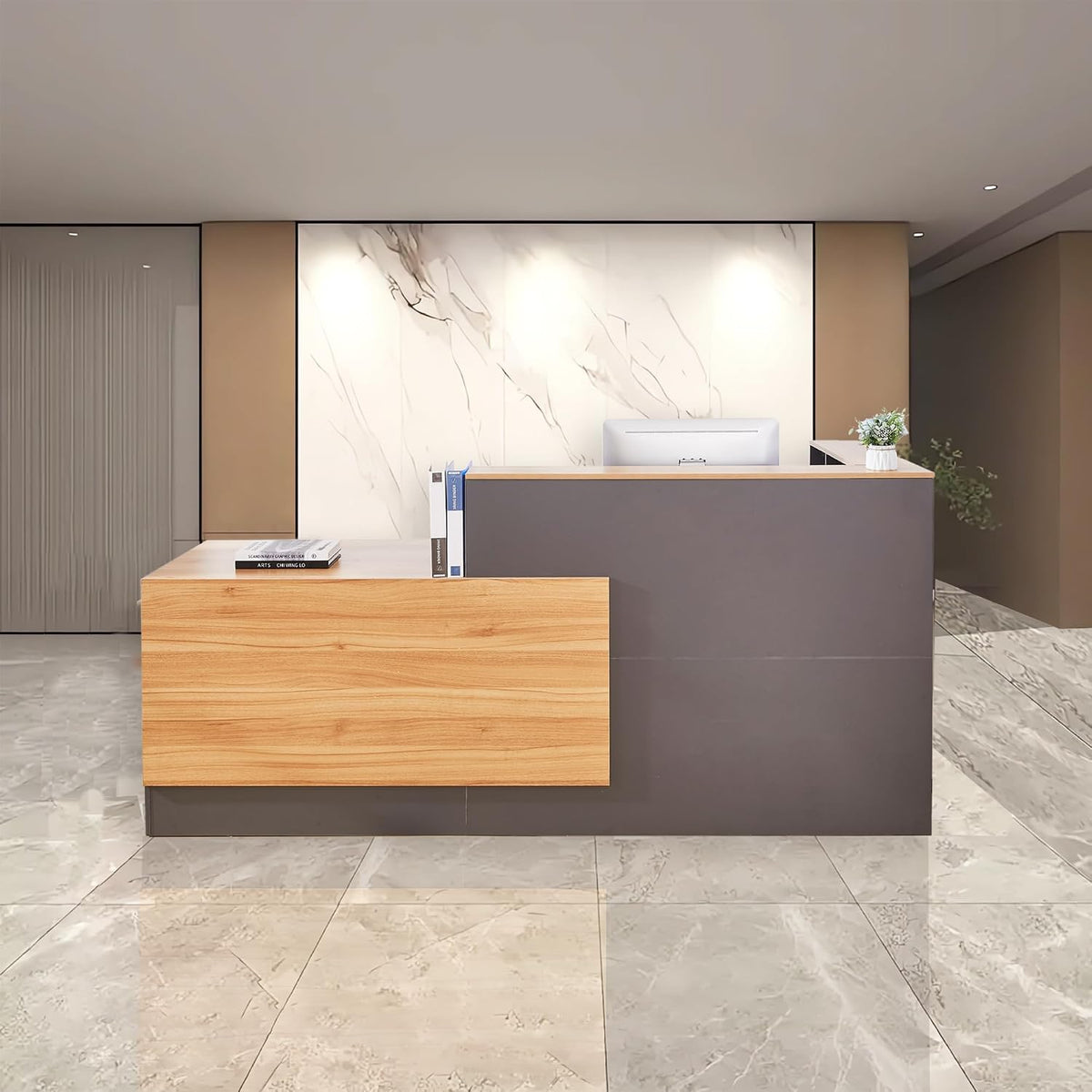 Wide lobby shot of a left-facing L-shaped reception counter with wood accent and computer monitor behind it.