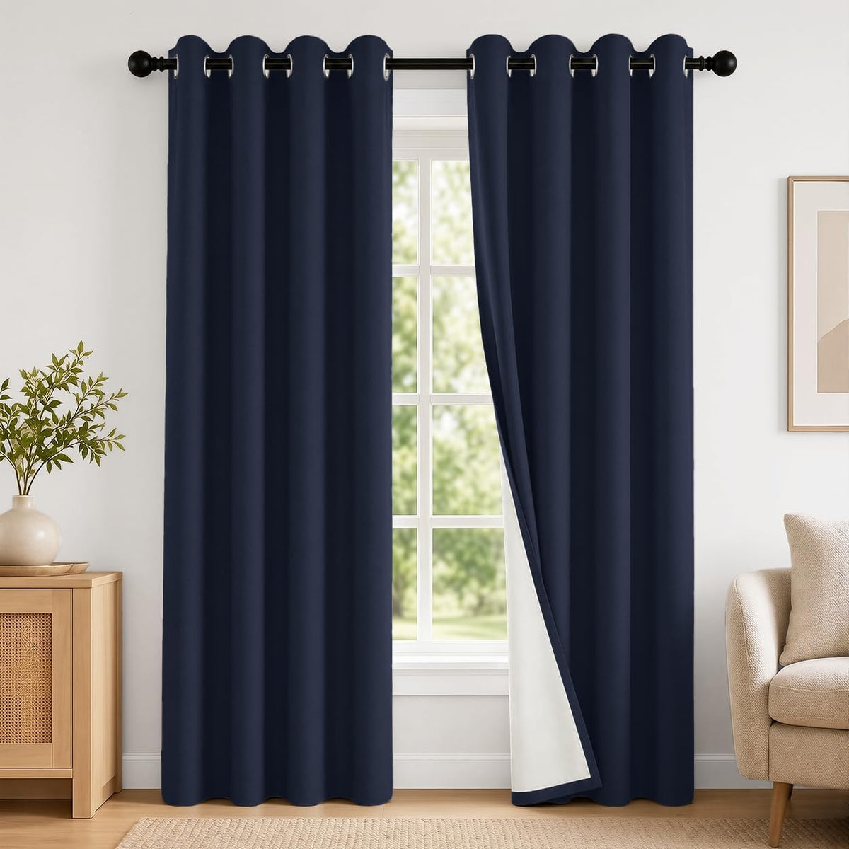 Pair of navy blue grommet curtains at a window, right panel folded back to show white backing