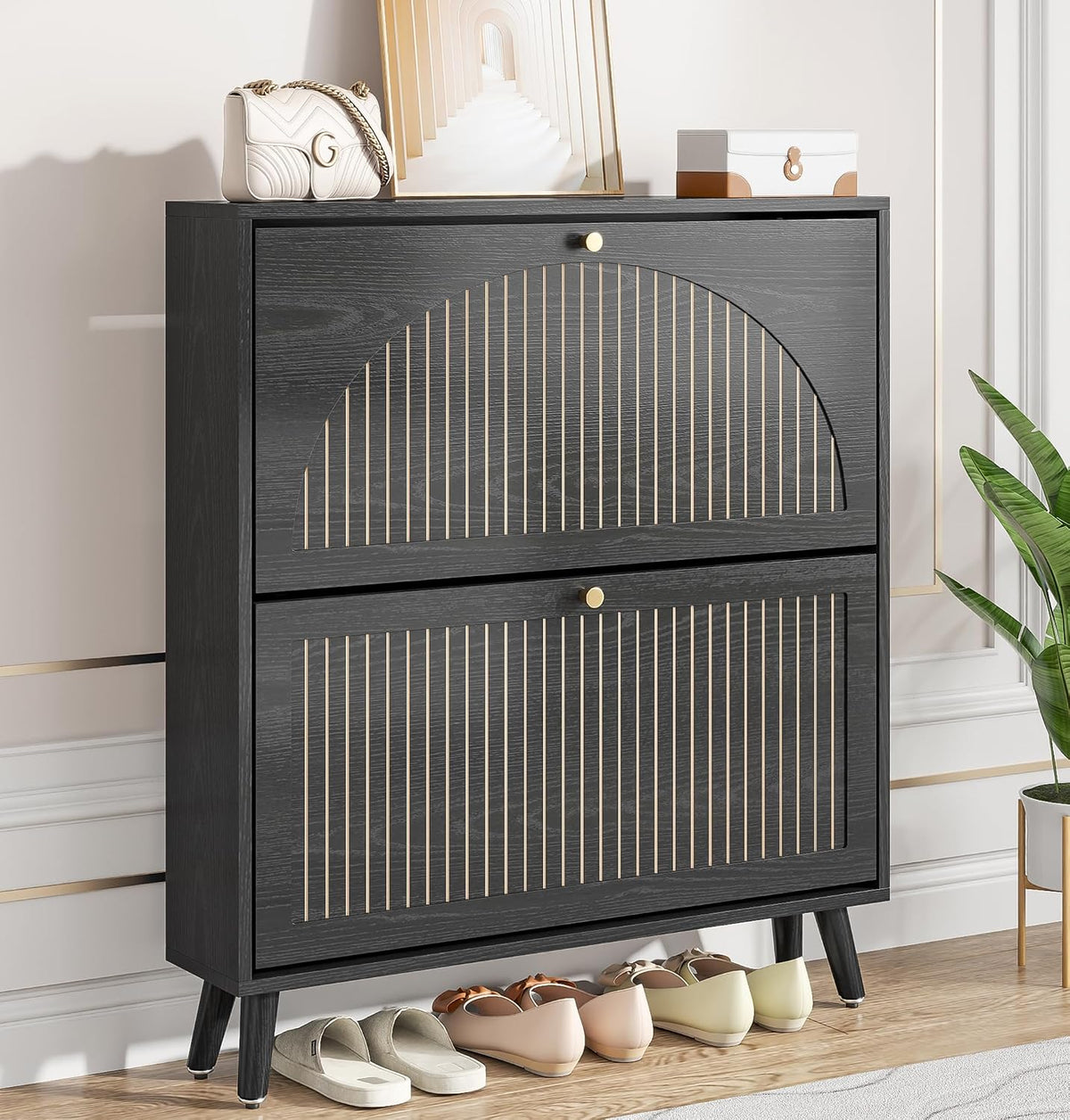 Dark wood two-drawer shoe cabinet with fluted semicircle detail, small round knobs and shoes underneath