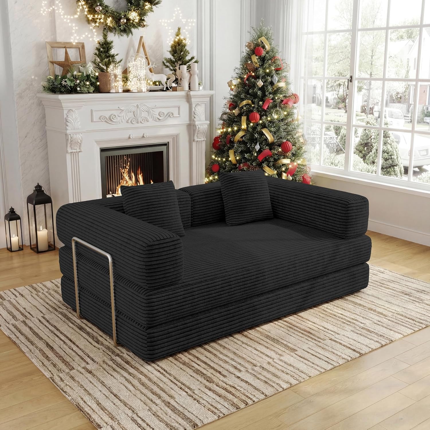 Black corduroy 2-seat convertible floor sofa shown angled in a living room with Christmas tree