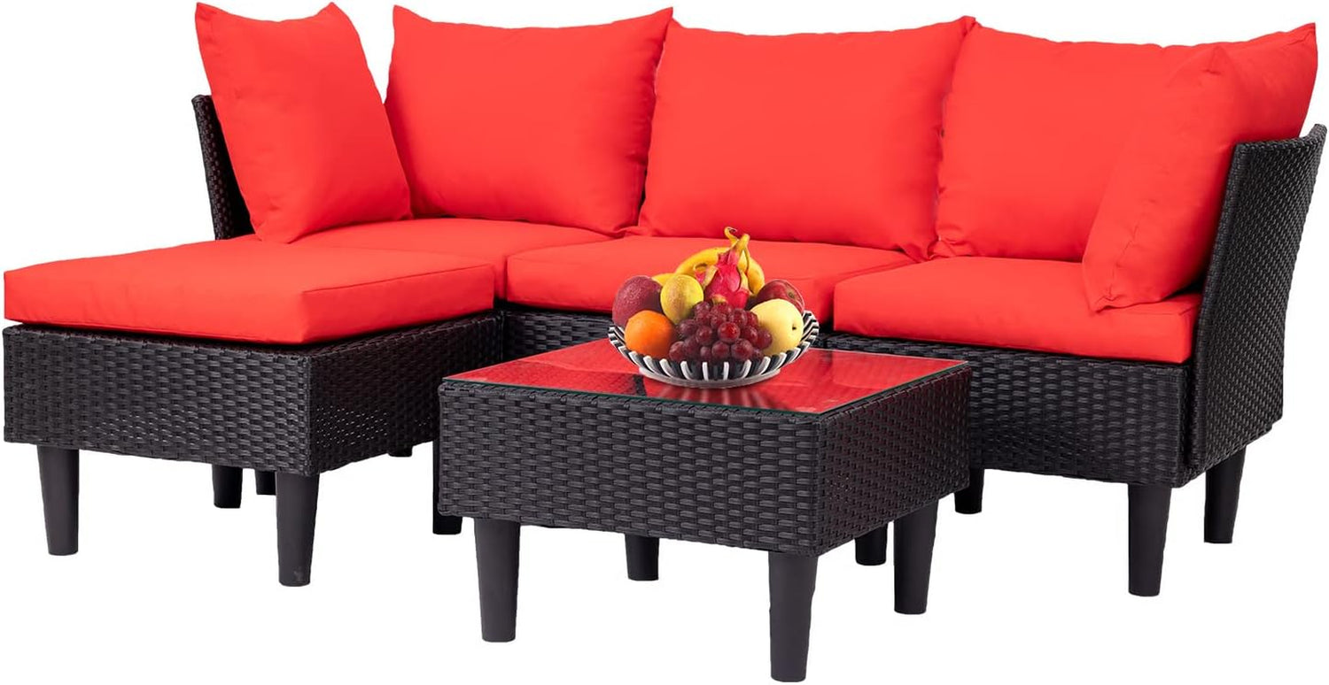 Modular corner rattan sofa with red cushions and a square glass-top coffee table holding a fruit bowl