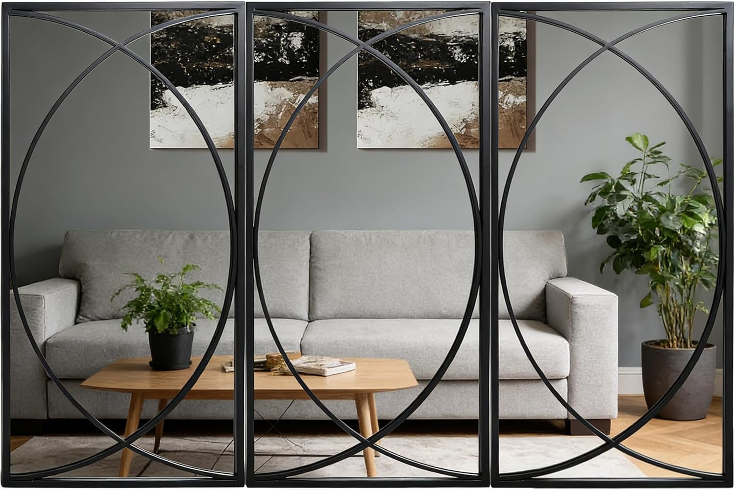Three slim black-framed rectangular mirrors with intersecting circular metal pattern reflecting a living room sofa