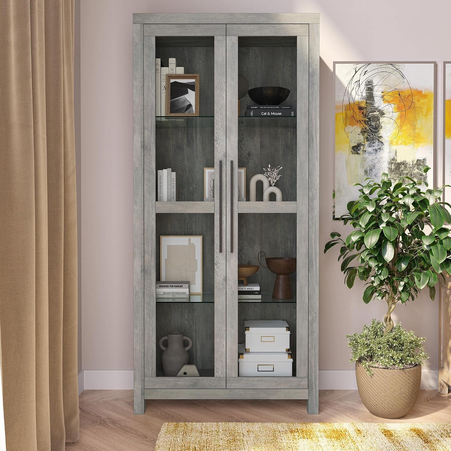 Front view of gray wash glass display cabinet styled with decor in a living room setting