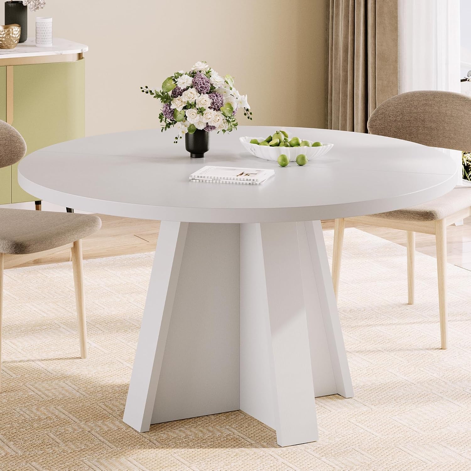 Round white dining table with paneled pedestal base and floral centerpiece