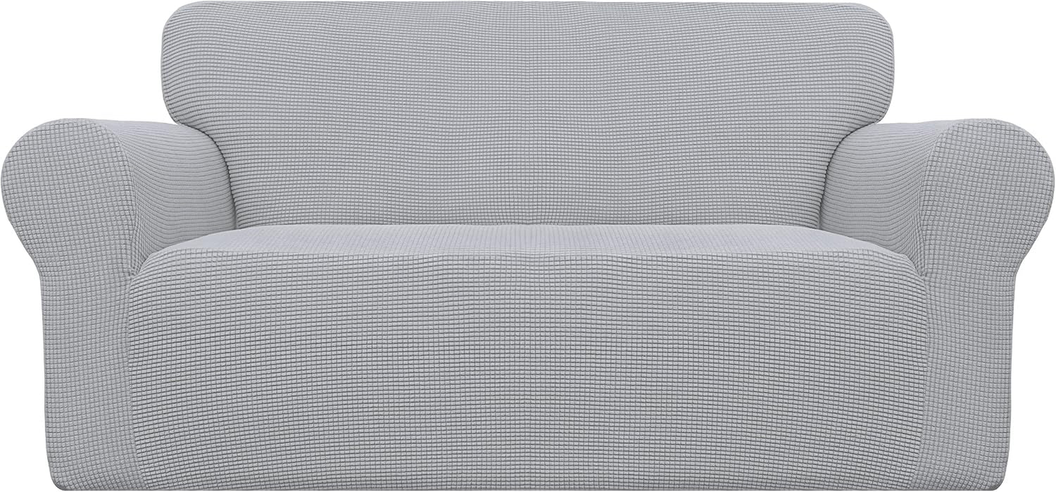 Front-facing loveseat covered in a light gray textured stretch slipcover, showing rounded arms.