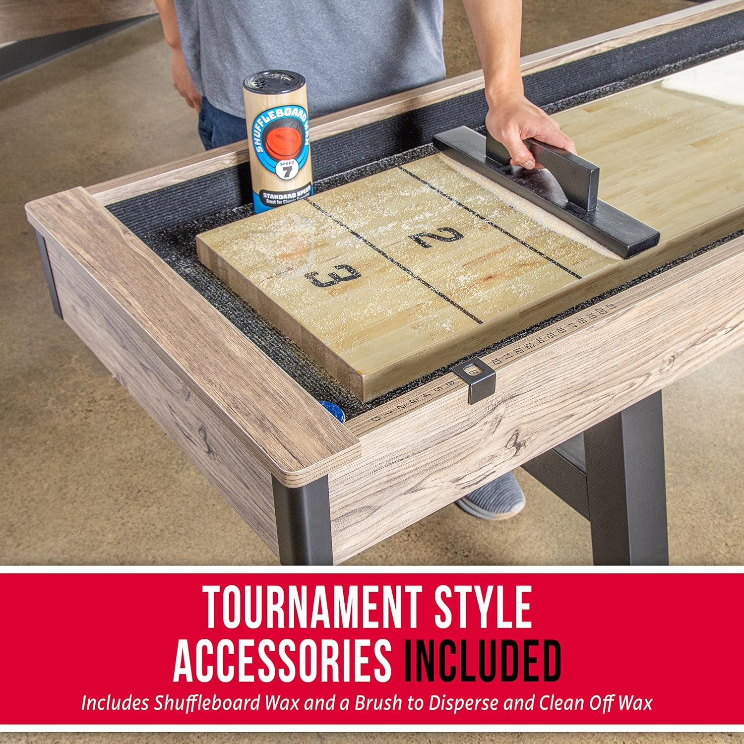 Hand using a push block on the composite butcher block playing surface with a canister of shuffleboard wax and tabletop brush
