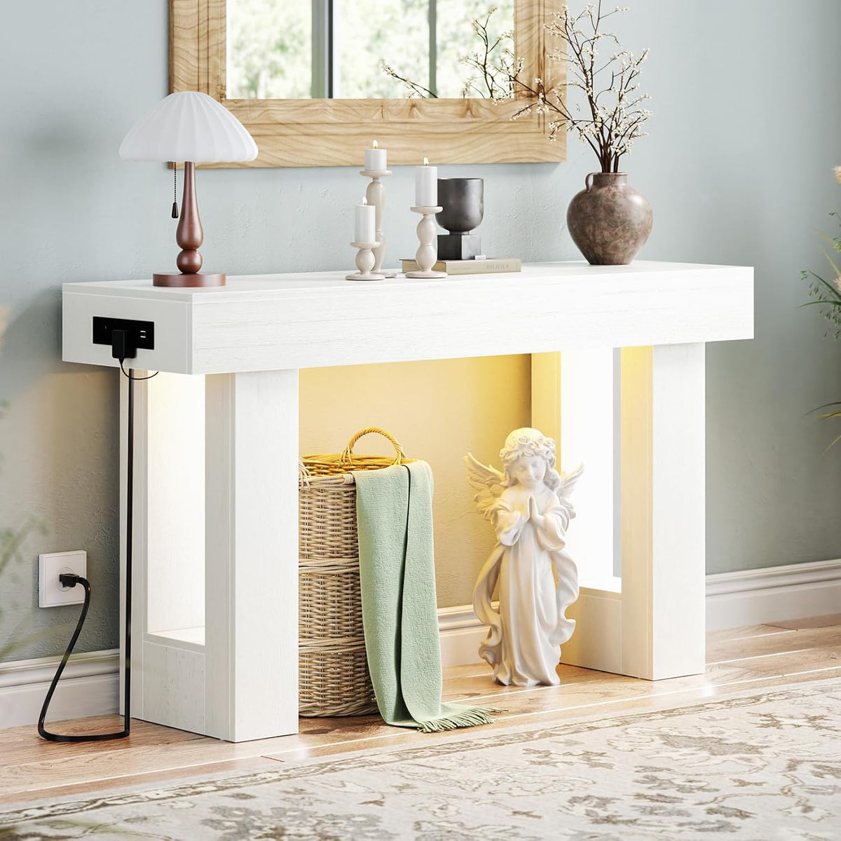 Straight-on shot of the white console table staged with a lamp, candles, vase and glowing shelf cavity