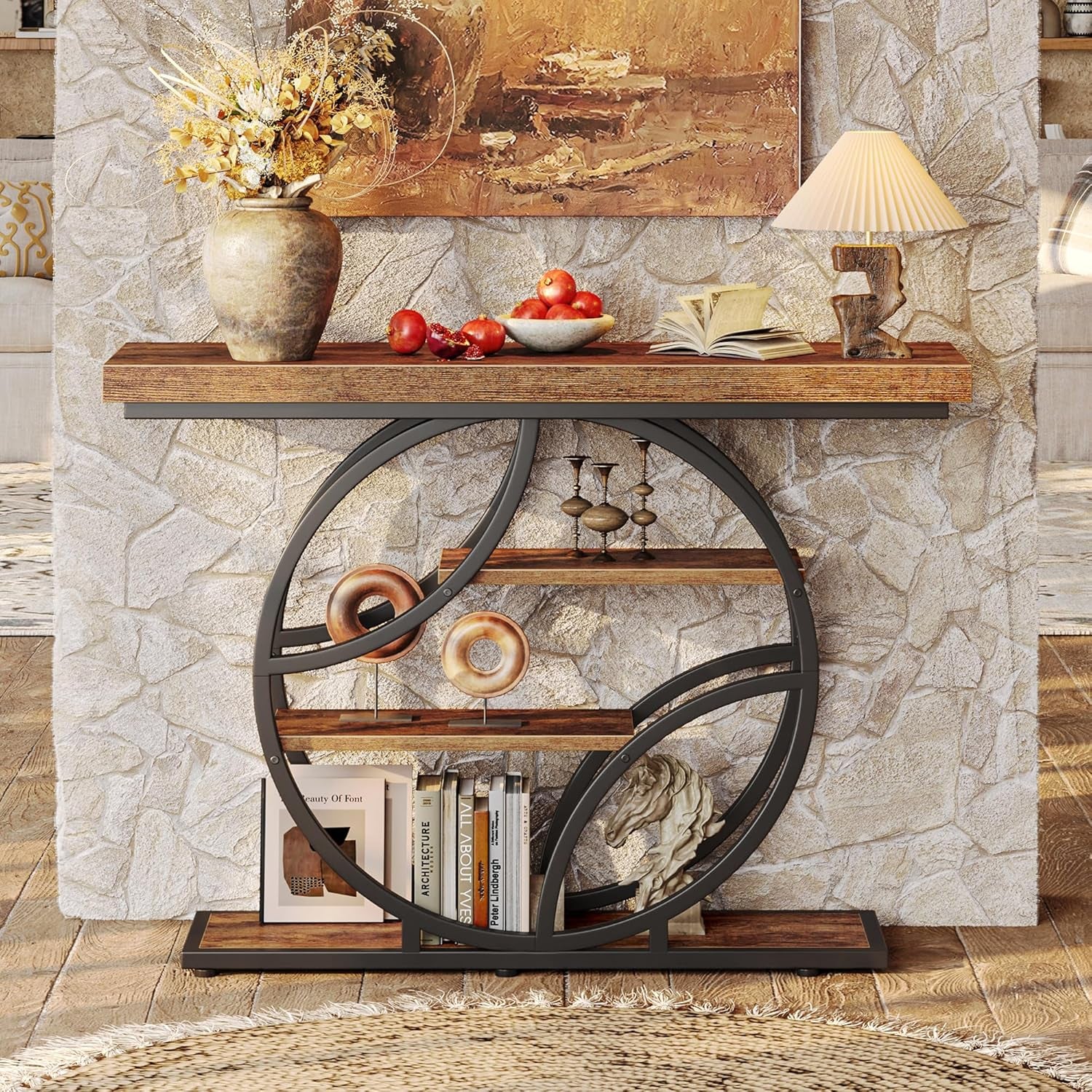 Straight front view of the rustic console table with circular metal frame and three shelves against a stone wall
