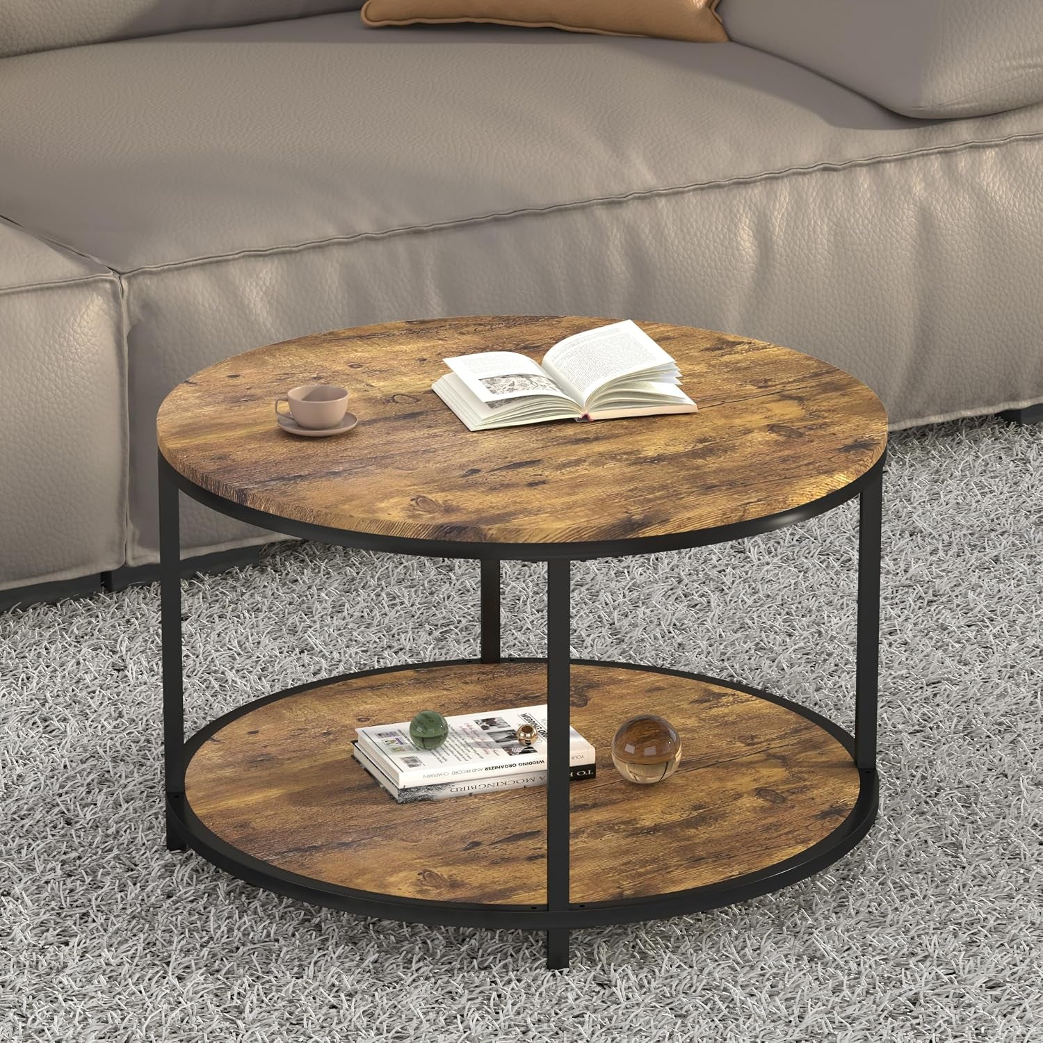 Round two-tier coffee table with warm wood-look top and lower shelf beside a sofa
