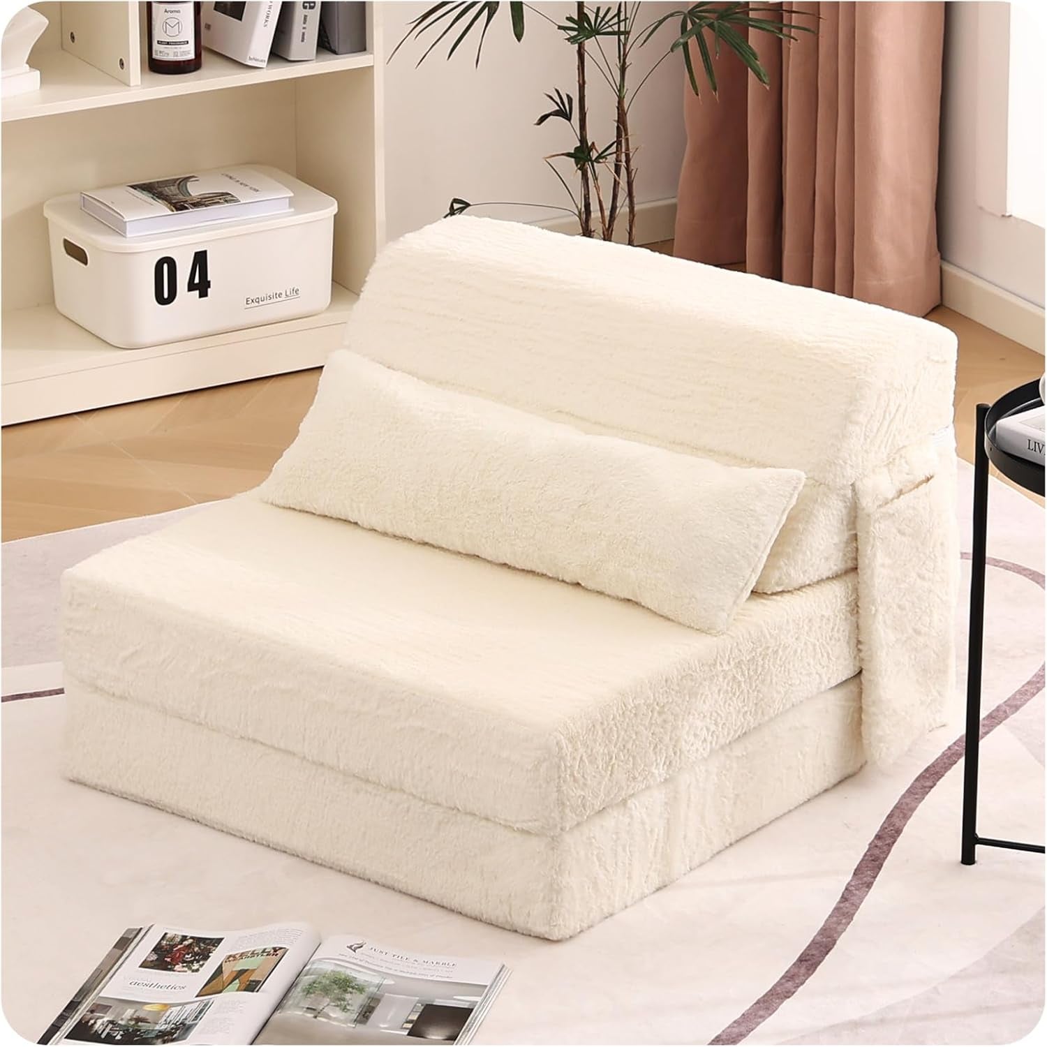 Cream foldable floor sofa chair with matching lumbar pillow beside shelving
