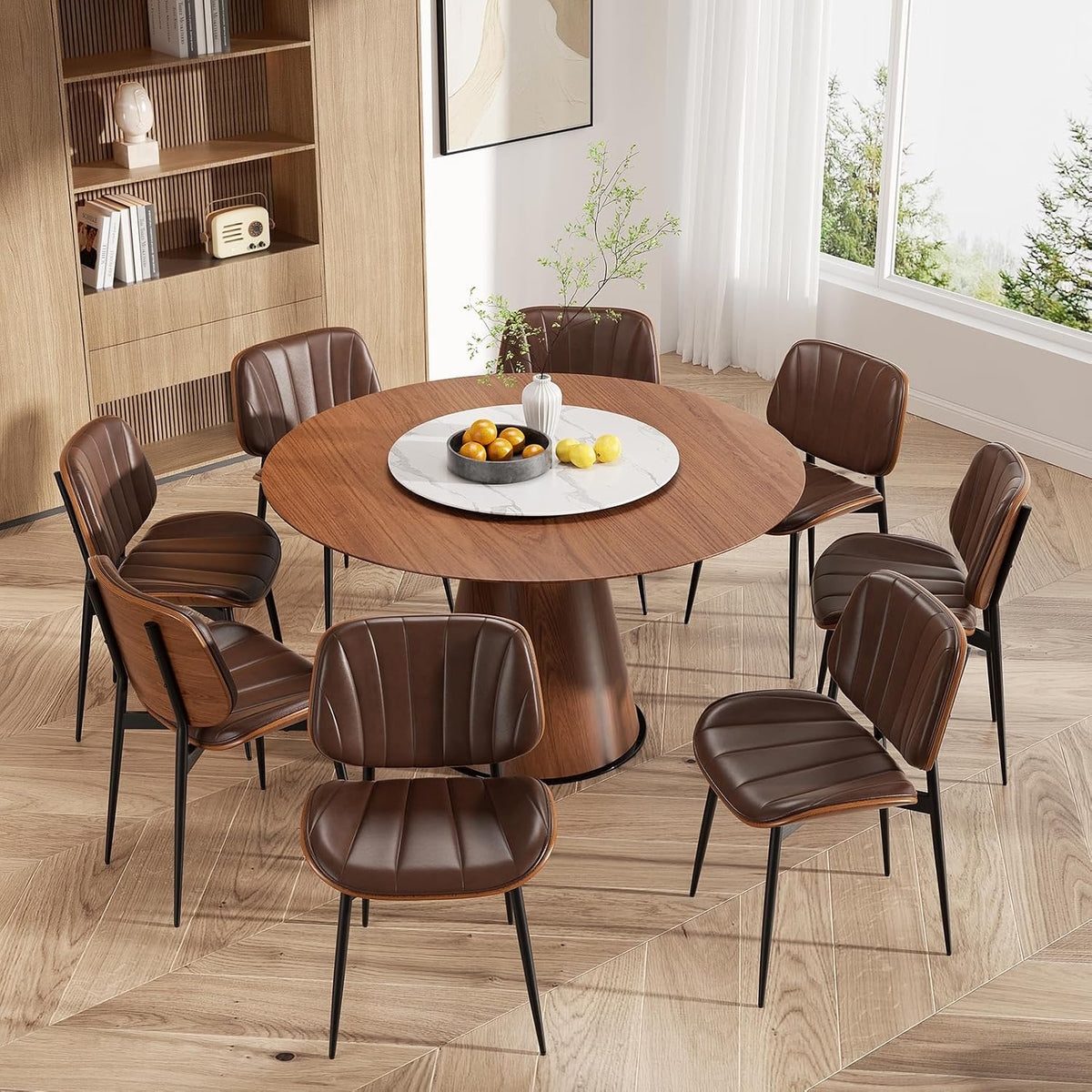 Round wood dining table surrounded by eight brown faux-leather chairs with walnut backs.