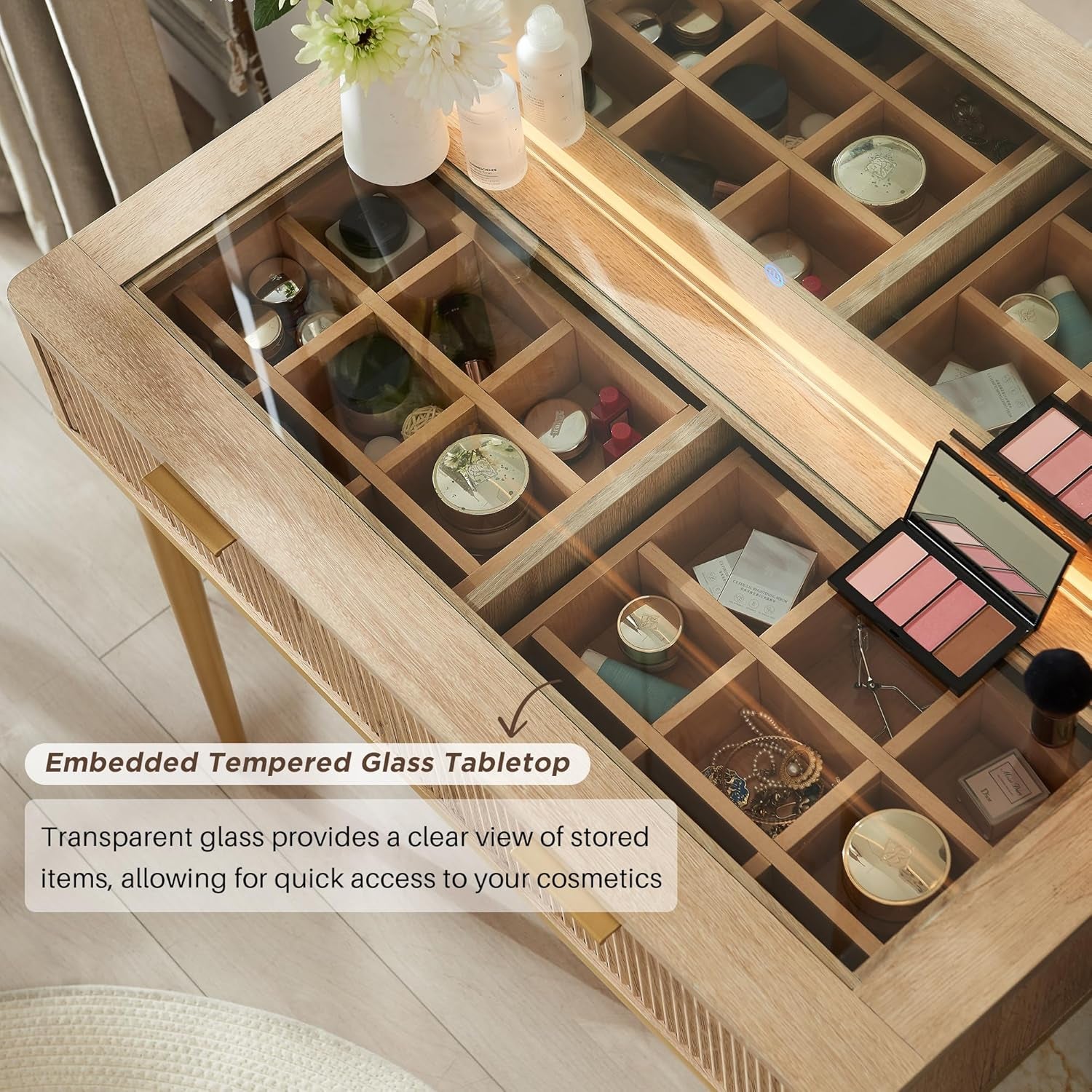 Top-down view of the vanity's clear glass-topped surface revealing divided cosmetic storage compartments beneath