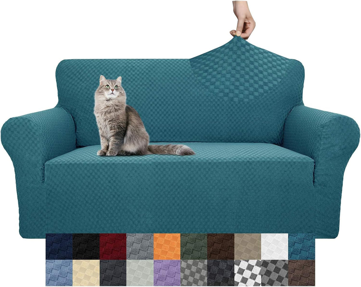 Front view of teal textured slipcover on a two-seat sofa with a long-haired gray cat and a hand lifting the back fabric