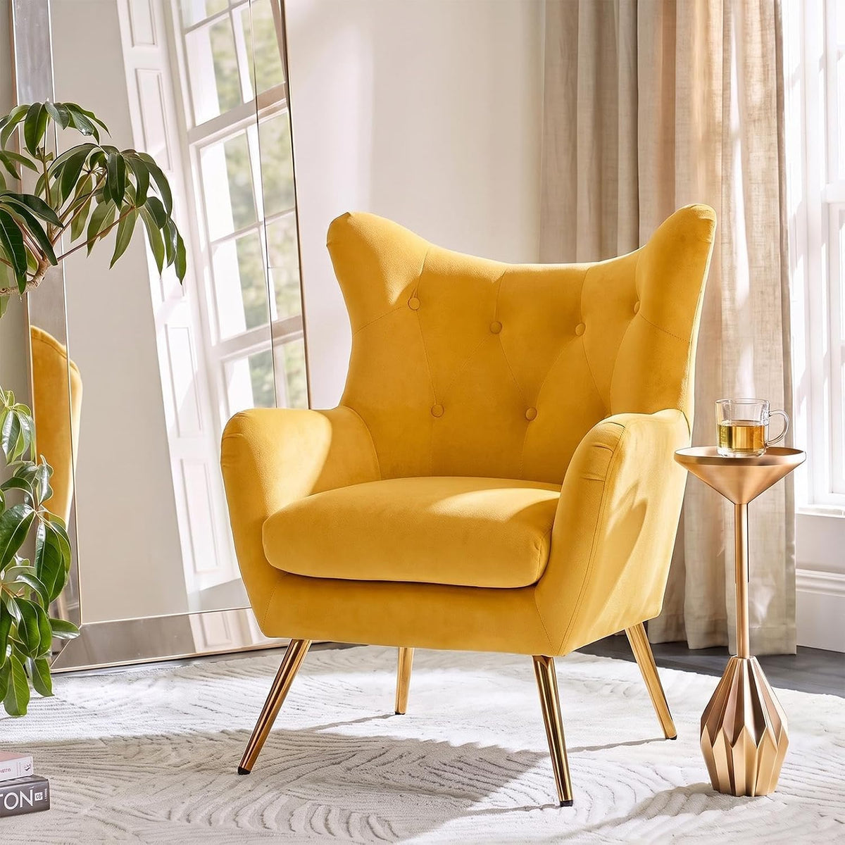 Mustard yellow velvet wingback chair accented by a gold geometric side table and window light.