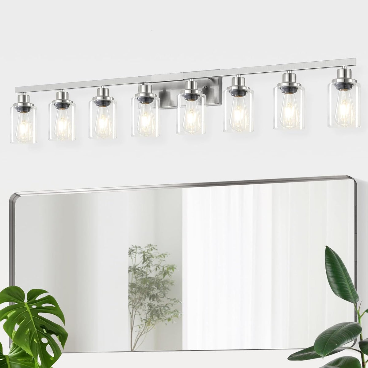 Long eight-light vanity bar with clear cylindrical shades mounted above a mirror