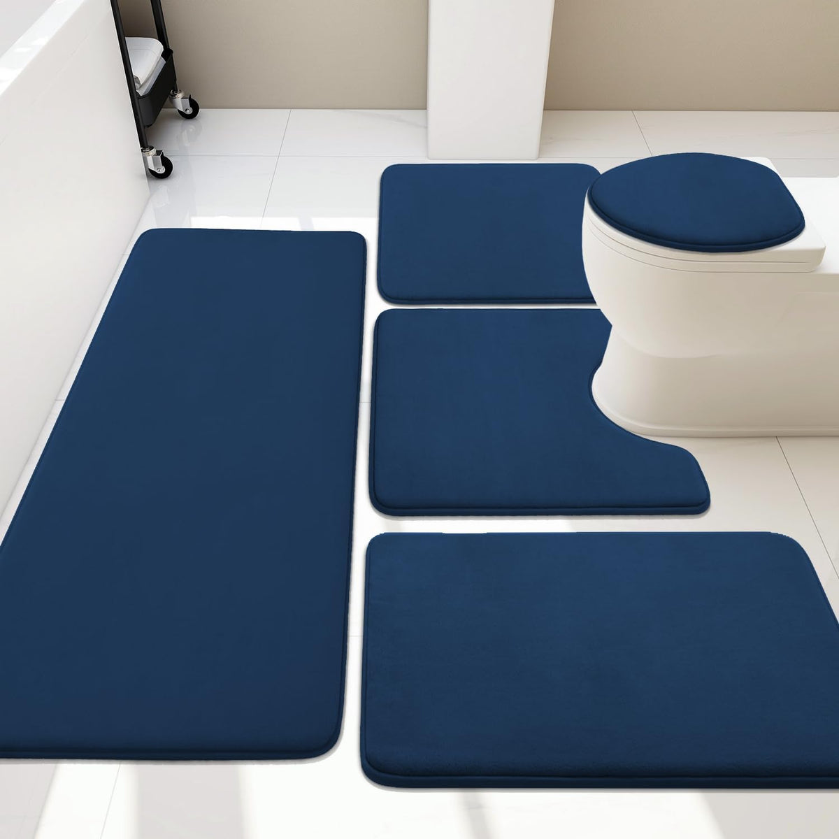 Overhead bathroom view showing a navy blue five-piece memory foam rug set around a toilet.