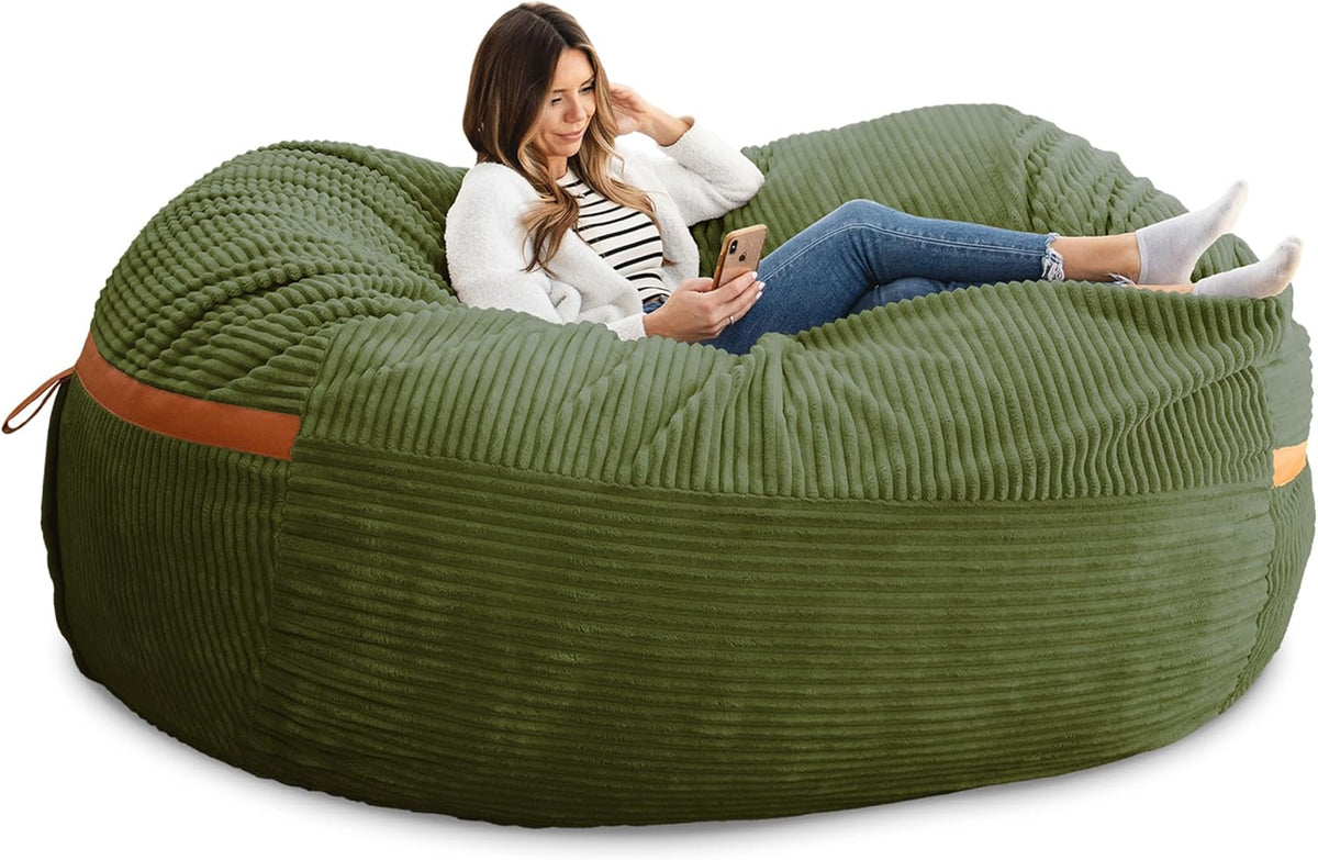 Woman lounging and using her phone on an olive-green ribbed bean bag with a tan strap