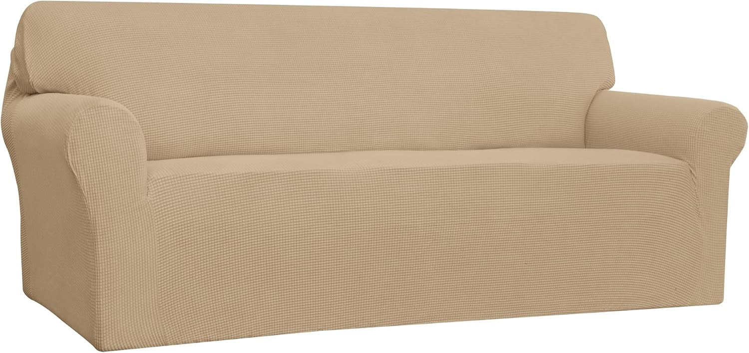 Three-quarter view of a beige loveseat with a fitted stretch cover showing the seat and curved arm contours.