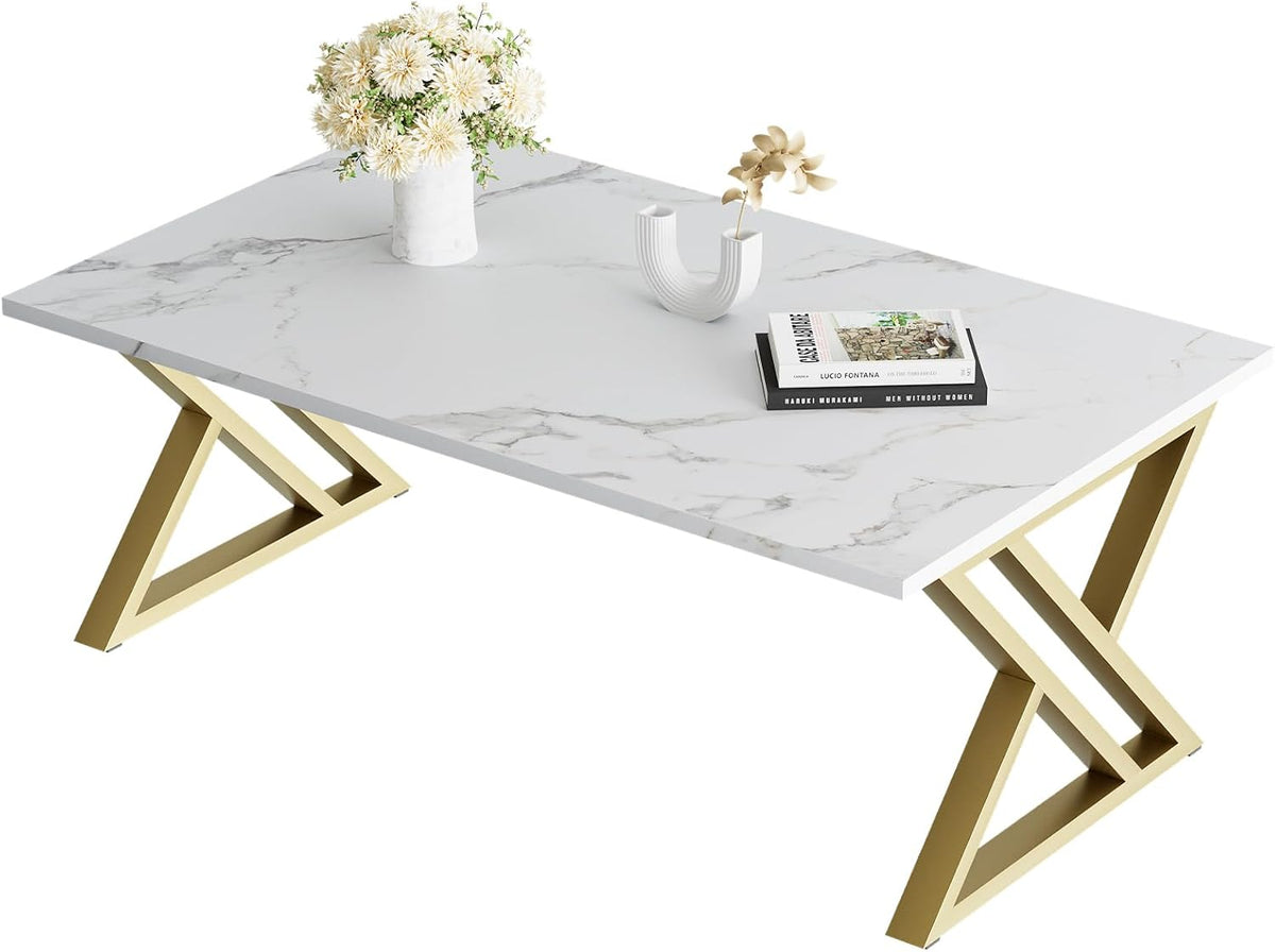 White faux marble rectangular coffee table with gold X-shaped steel legs, angled top view