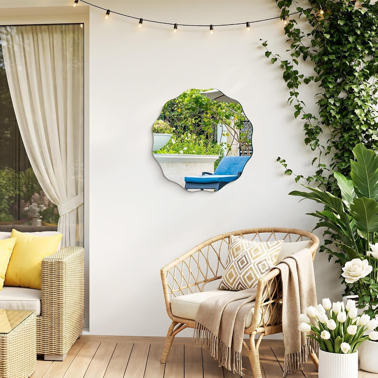 Scalloped mirror on an exterior wall reflecting a blue lounge chair and garden plants, with string lights above.