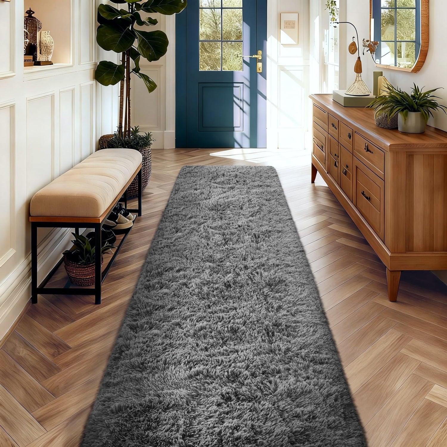 Long gray shag runner laid down a sunlit entryway with bench and wooden console