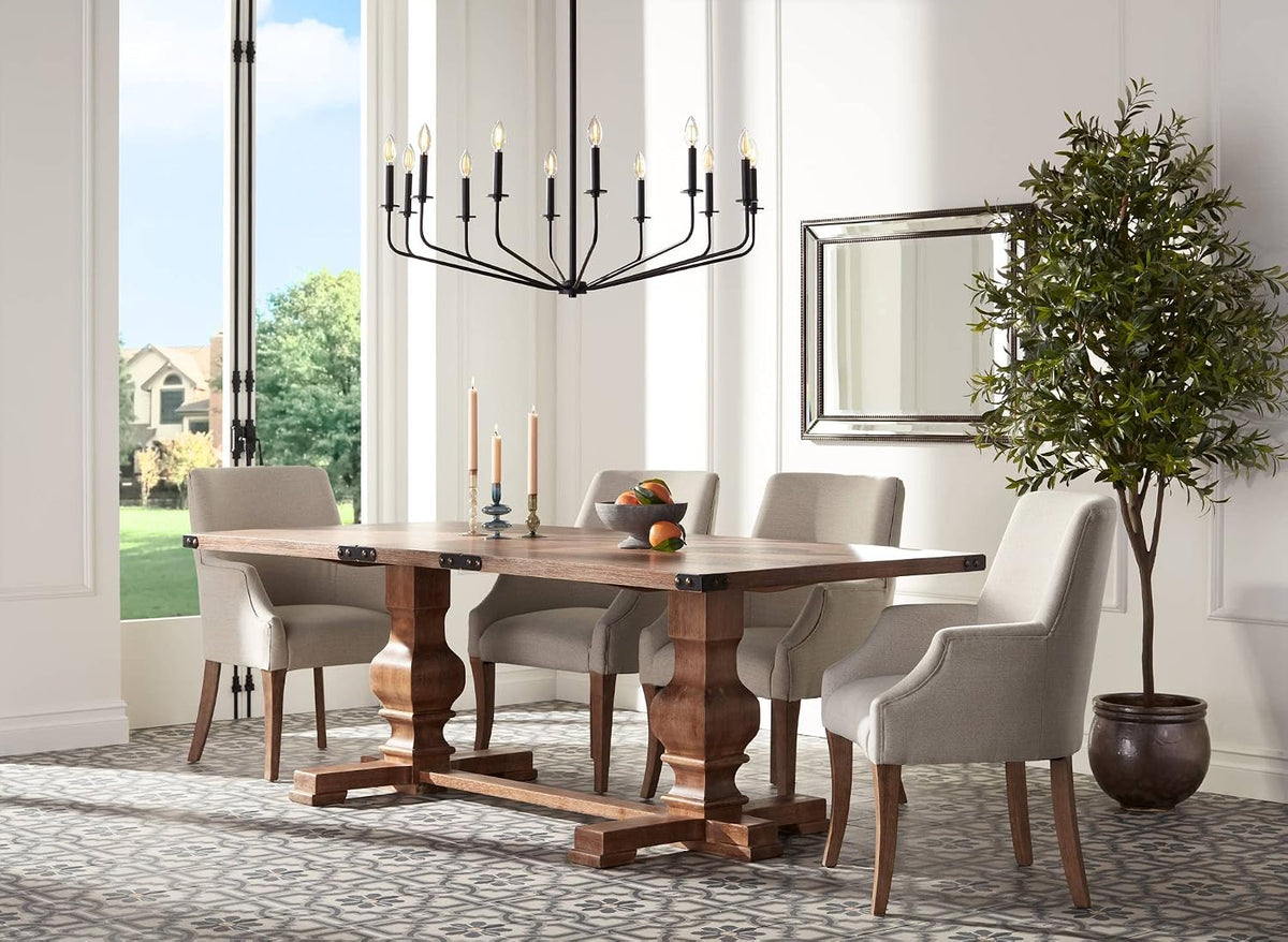 Dining room view with the beaded bronze rectangular mirror on the wall beside a tall potted tree and a wood trestle table.