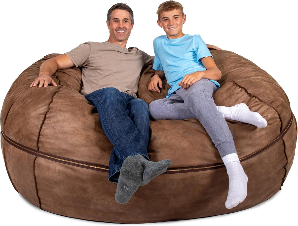 Man and teen boy sitting together on a large brown lounger with a visible horizontal zipper.