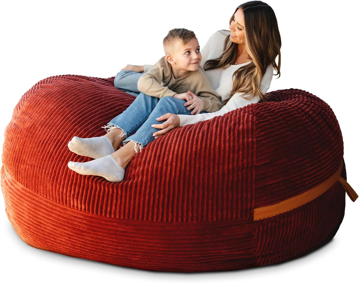 Mother and child reclining on a ribbed red oversized lounger with a tan strap accent at the side