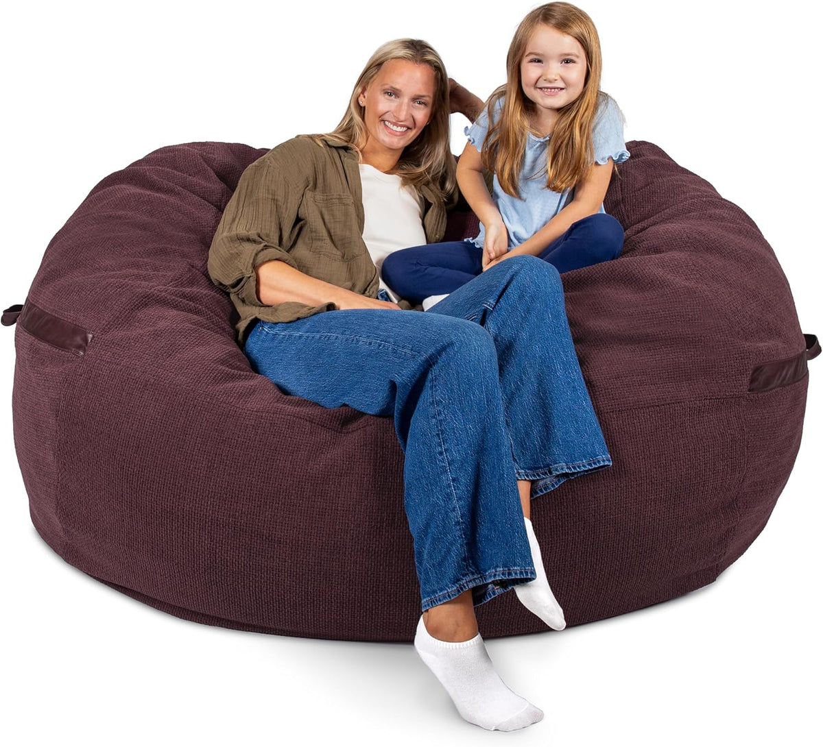 An adult and child sitting together in a large plum-colored lounger with stitched handle detail.