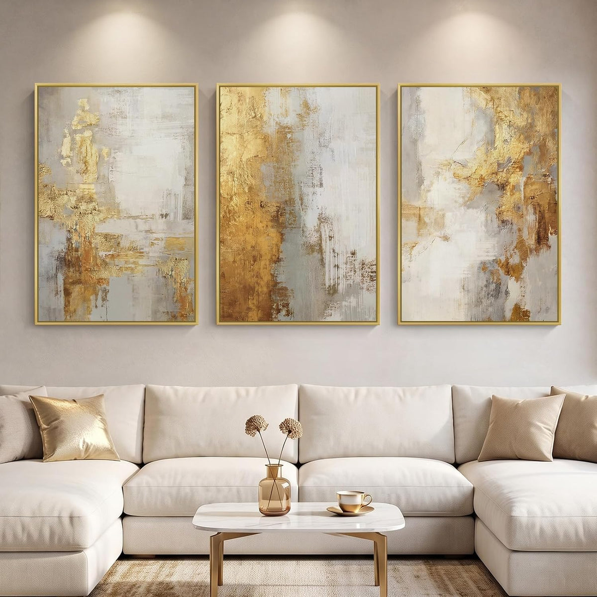 Three vertical framed abstract panels with gold and cream textured brushstrokes above a cream sectional sofa.