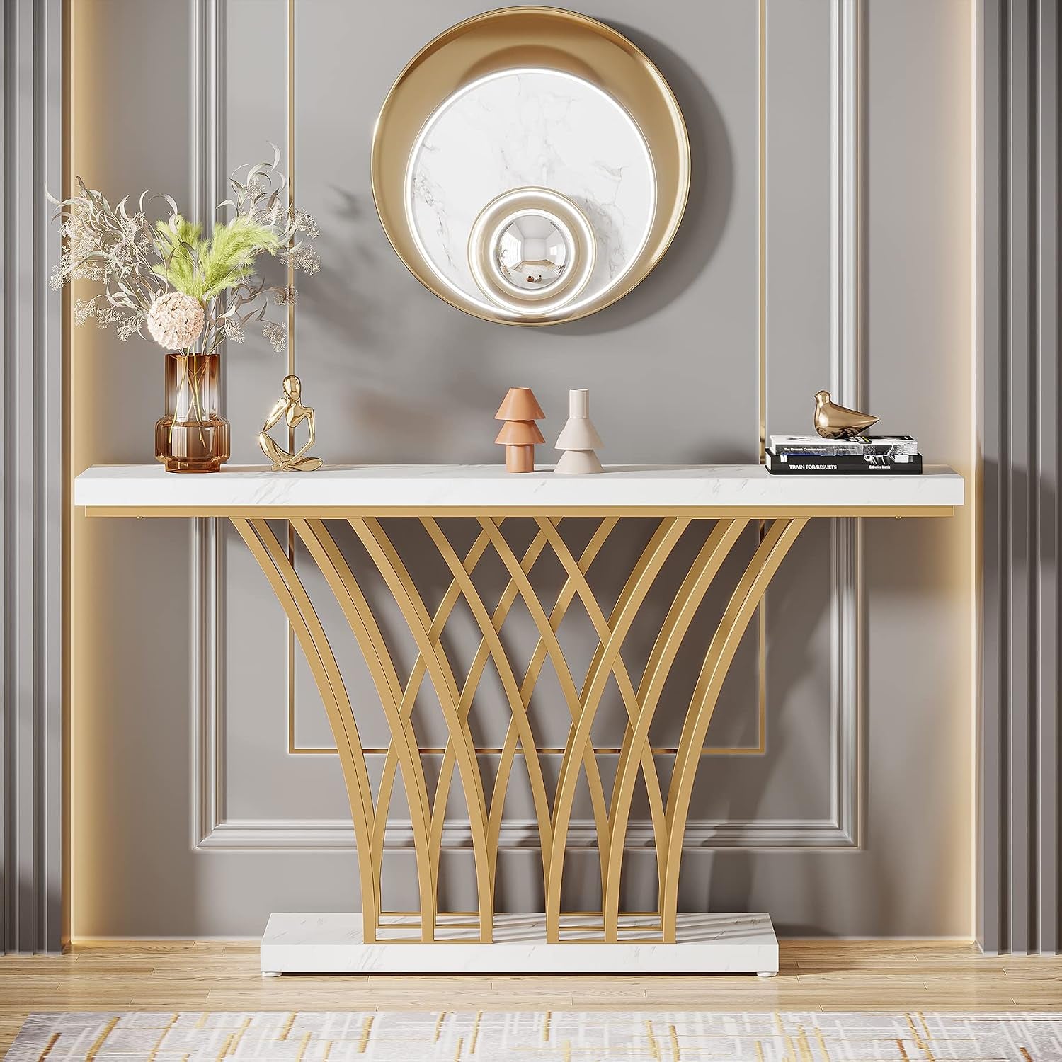 Front view of white faux marble console table with arched gold metal supports under a round mirror